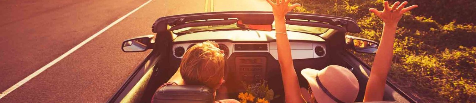 a couple riding in a convertible. 