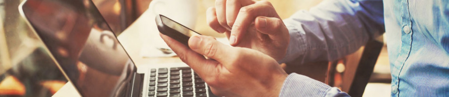 a person working on their mobile and laptop