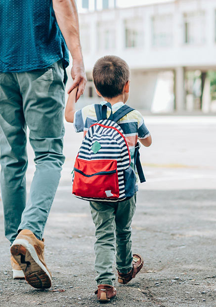 Boy and father walking across the street