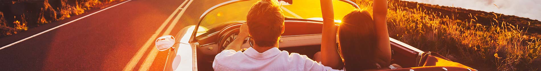 couple driving with top down on the highway