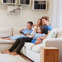 Family watching television in their living room together