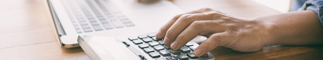 Man using laptop computer and calculator