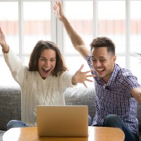 excited couple with their hands in the air