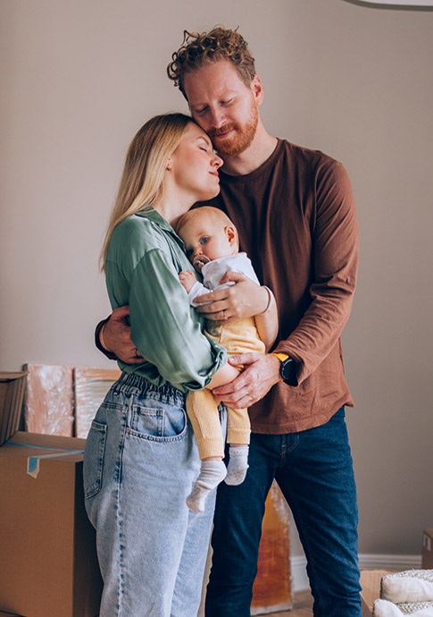 Couple hugging their child in new house